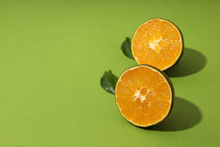 Halves of chocolate orange on green backgroundの写真素材