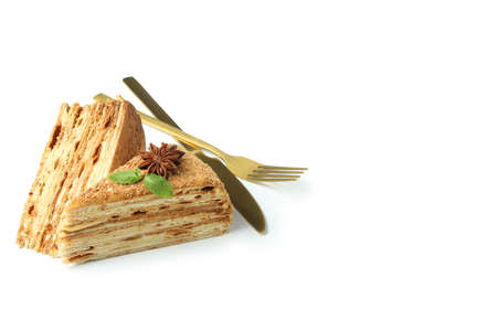 Pieces of honey cake and cutlery isolated on white backgroundの写真素材