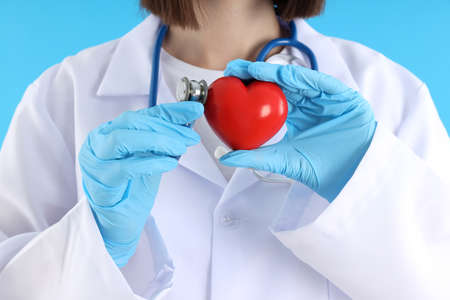 Female trainee doctor with heart on blue background