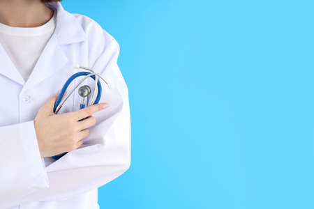 Female trainee doctor with stethoscope on blue background