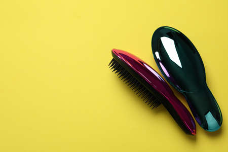 Colored plastic hair brushes on yellow backgroundの写真素材