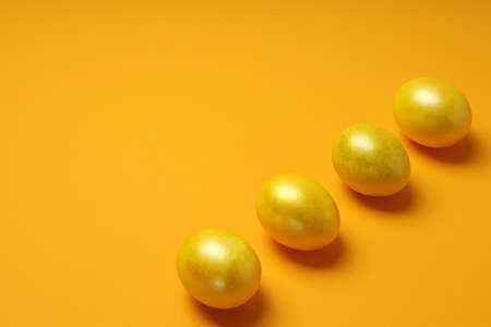 Easter eggs on orange background, space for textの写真素材