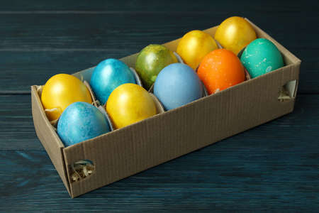 Box with Easter eggs on wooden background, close upの写真素材