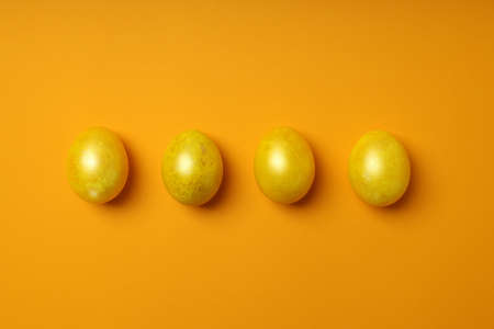 Easter eggs on orange background, top viewの写真素材
