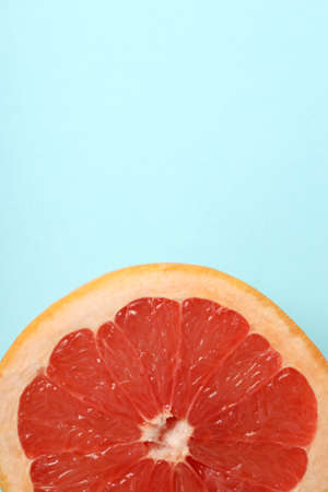 Half of grapefruit on blue background, top viewの写真素材
