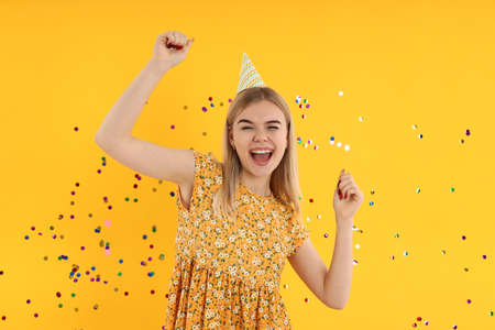 Concept of Happy Birthday with young woman on yellow backgroundの写真素材