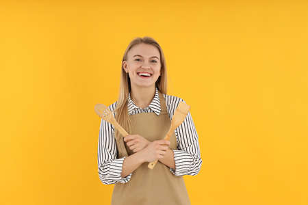 Concept of cooking with young woman on yellow backgroundの写真素材