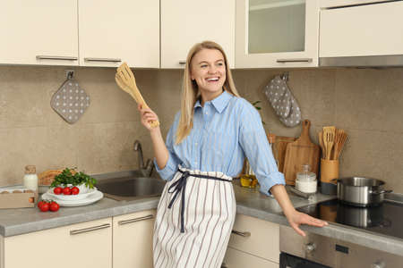 Concept of cooking with young attractive woman in kitchen roomの写真素材