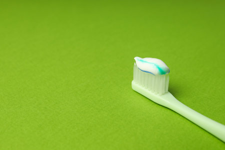 Toothbrush with toothpaste on green background, space for textの写真素材