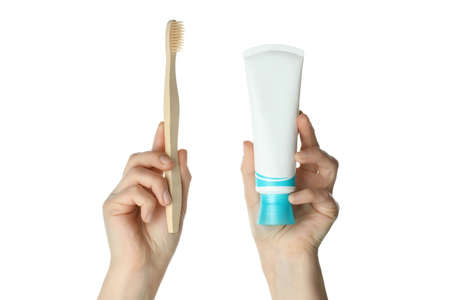 Female hands hold toothpaste and toothbrush, isolated on white backgroundの写真素材