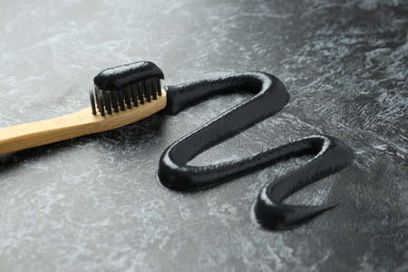 Wooden toothbrush with black toothpaste, close up