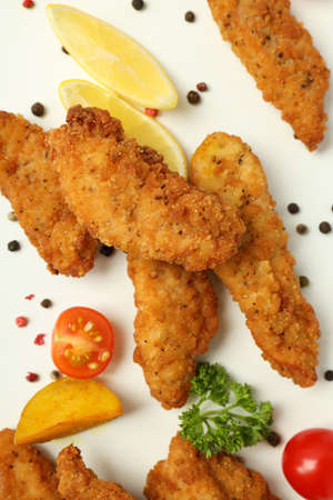 Concept of tasty food with chicken strips on white background