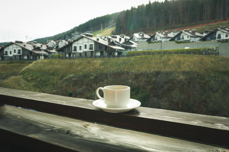 Cup of coffee on wooden balcony in ski resortの写真素材