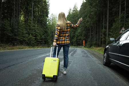 Adventure and tourism concept, young woman traveling by auto stopの写真素材
