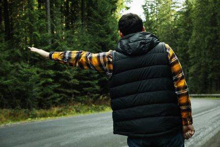 Adventure and tourism concept, young man traveling by auto stopの写真素材