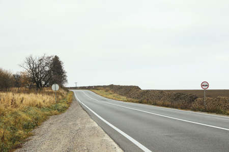 Asphalt road against field with beetroot pilesの写真素材