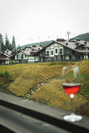 Glass of wine on wooden balcony in ski resort