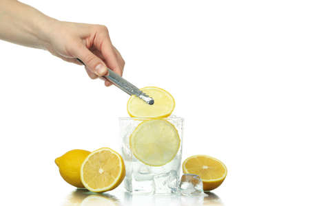 Female hand puts lemon slice in glass, isolated on white background