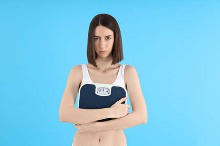 Concept of weight loss, young woman on blue backgroundの写真素材