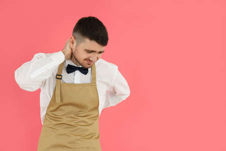 Concept of occupation, young waiter on pink backgroundの写真素材