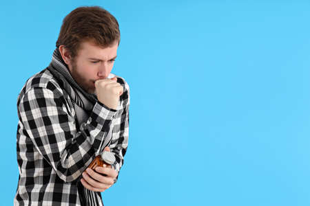Young man with cold on blue background