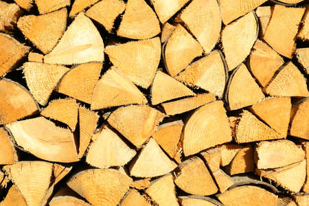 Background of dry chopped firewood logs in a pile