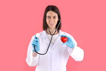Attractive young female doctor on pink backgroundの写真素材