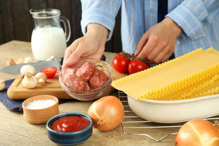 Concept of cooking, woman in shirt cooking lasagna