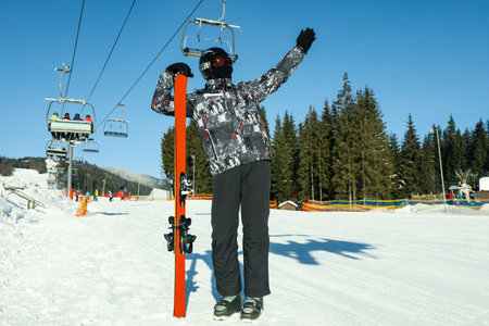 Happy male skier in mountain resort in sunny dayの写真素材
