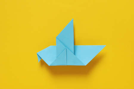 Blue paper bird on yellow background, Save Ukraine conceptの写真素材