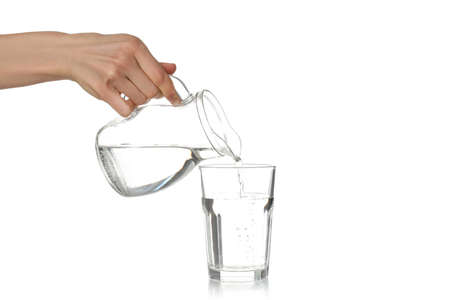 Female hand pour water in glass, isolated on white background
