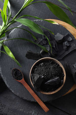 Natural charcoal and powdered charcoal on dark wooden backgroundの写真素材