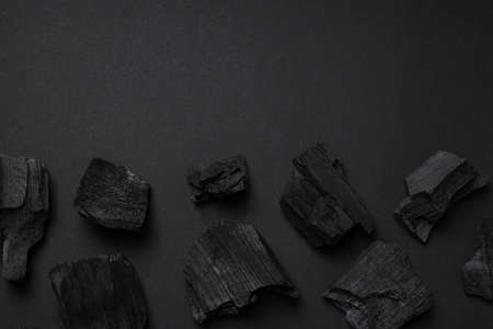 Flat lay with natural charcoal on black background