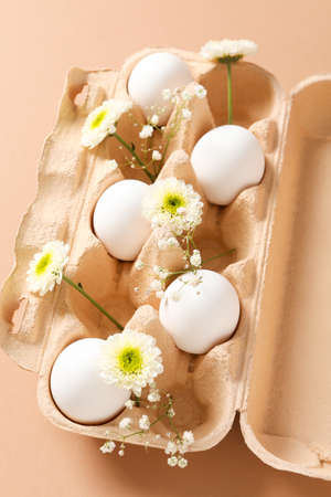 Concept of spring, eggs with flowers on beige background
