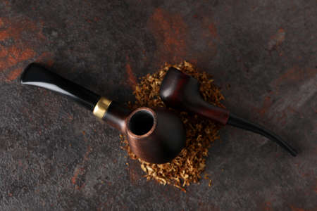 Smoking pipes with tobacco on dark textured backgroundの写真素材