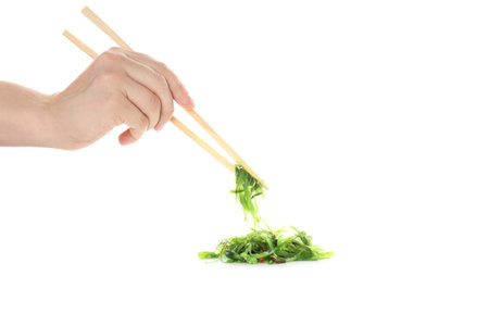 Hand holds Chuka with chopsticks, isolated on white backgroundの写真素材