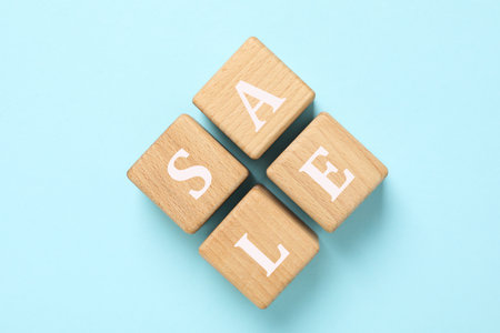 Wooden cubes with text Sale on blue backgroundの写真素材