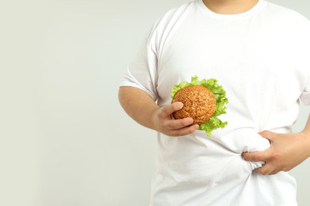 Concept of weight problems, young fat man on light backgroundの写真素材