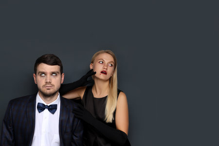 Concept of Halloween, young man and woman on dark backgroundの写真素材