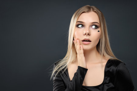 Concept of Halloween, young woman on dark backgroundの写真素材