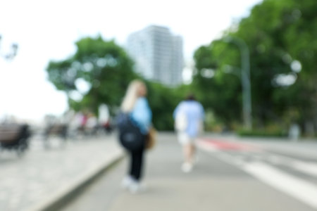 Two young women walking in city, blurred photoの写真素材