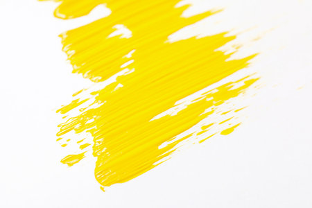 White background with bright yellow paint smearの写真素材
