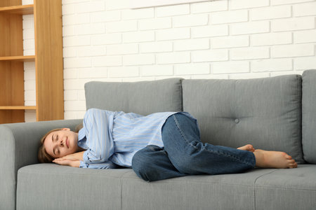 Young woman sleep on sofa in cozy modern flatのeditorial素材