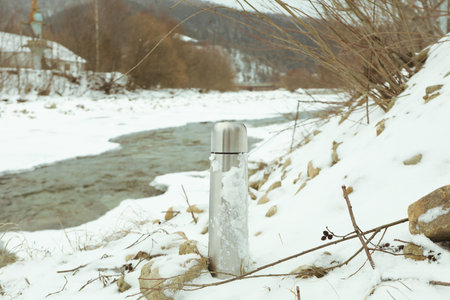 Casual steel thermo standing outdoor near the riverの写真素材