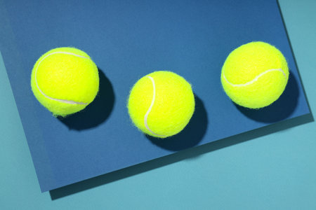 Tennis balls on two tone blue backgroundの写真素材