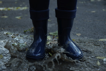Person in rubber boots outdoor in rainy weatherの写真素材