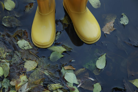 Yellow rubber boots outdoor in rainy weather