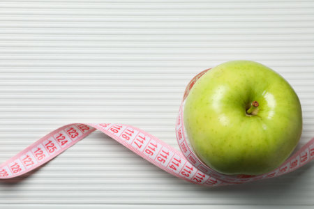 Diet and weight loss, healthy lifestyle, composition with measuring tape, space for textの写真素材