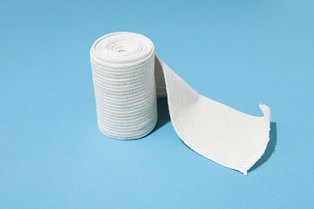 Concept of help during an injury, elastic bandage on blue backgroundの写真素材
