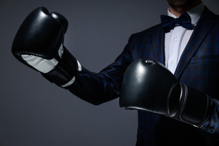 Businessman in boxing gloves on dark gray backgroundの写真素材